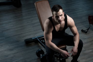 Yakışıklı ve çekici bir genç adam. Vücut kasları spor salonunda dinleniyor.