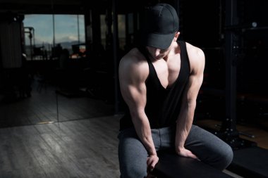 Yakışıklı ve çekici bir genç adam. Vücut kasları spor salonunda dinleniyor.