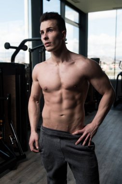 İyi eğitilmiş vücudunu gösteren genç bir adamın portresi - kaslı atletik vücut geliştirici spor sonrası vücut geliştirme modelliği pozu