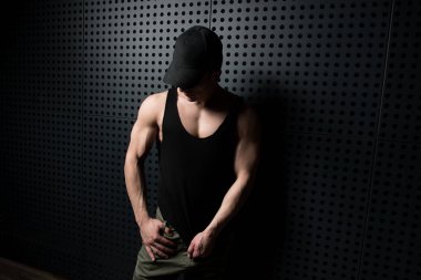 İyi eğitilmiş vücudunu gösteren genç bir adamın portresi mavi kot giyerken - kaslı atletik vücut geliştirici spor modeli pozu duvarın yanındaki duvarda egzersiz yaptıktan sonra - metinleriniz için bir yer