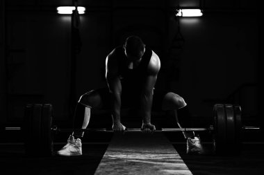 Profesyonel sporcu üzerinde halter eğildi ve bir çok ağır ağırlık kaldırmaya hazırlanıyor