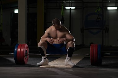 Yakışıklı ve çekici bir genç adam. Vücut kasları spor salonunda dinleniyor.