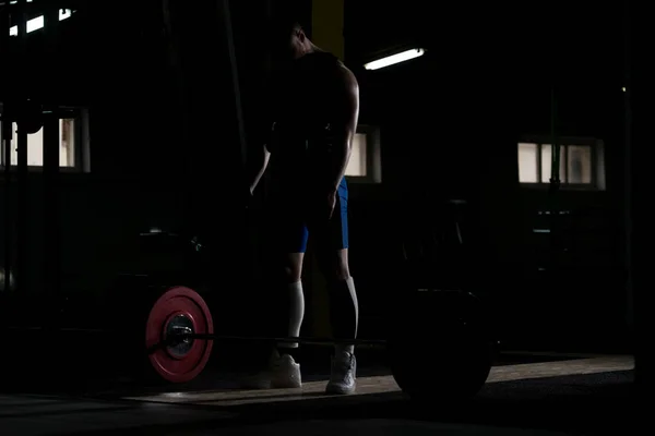 强壮的人准备从地板上解除沉重的杠铃在健身房的举重锻炼 — 图库照片