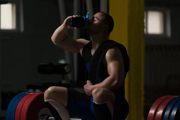 筋肉男運動後の休息とシェーカーから飲む — ストック写真