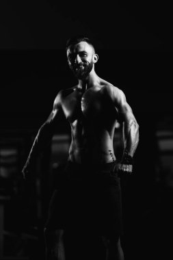 İyi eğitilmiş vücudunu gösteren genç bir adamın portresi - kaslı atletik vücut geliştirici spor sonrası vücut geliştirme modelliği pozu