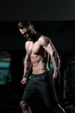 Yakışıklı Genç Adam Spor Salonunda Güçlü Duruyor ve Kaslarını Geriyor - Kas Atletik Vücut Geliştirici Spor Sonrası Spor Pozisyonu