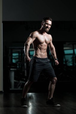 İyi eğitilmiş vücudunu gösteren genç bir adamın portresi - kaslı atletik vücut geliştirici spor sonrası vücut geliştirme modelliği pozu