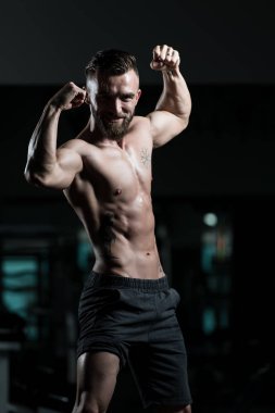 Yakışıklı Genç Adam Spor Salonunda Güçlü Duruyor ve Kaslarını Geriyor - Kas Atletik Vücut Geliştirici Spor Sonrası Spor Pozisyonu