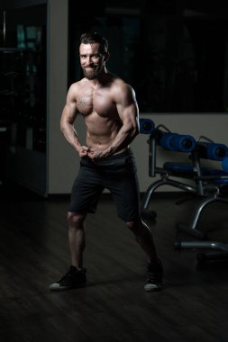 İyi eğitilmiş vücudunu gösteren genç bir adamın portresi - kaslı atletik vücut geliştirici spor sonrası vücut geliştirme modelliği pozu