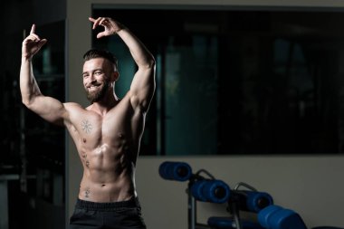 İyi eğitilmiş vücudunu gösteren genç bir adamın portresi - kaslı atletik vücut geliştirici spor sonrası vücut geliştirme modelliği pozu