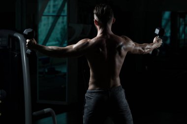 Çalışma dışarı bir spor salonunda Dumbbells ile omuz adam