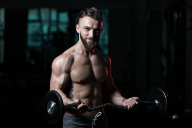 Spor salonunda bilardo oynayan sporcu halterle kıvrılıyor.