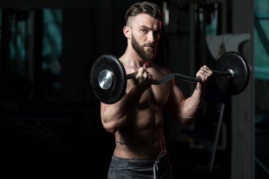 Spor salonunda bilardo oynayan sporcu halterle kıvrılıyor.