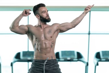 Spor Salonunda Güçlü Duran Genç Adam - Kas Atletik Vücut Geliştirici Spor Sonrası Spor Pozisyonu