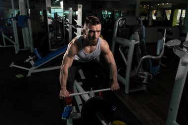 Sırt üstü ağırlıklar ile makine için ağır egzersiz yaparak yakışıklı vücut geliştirmeci