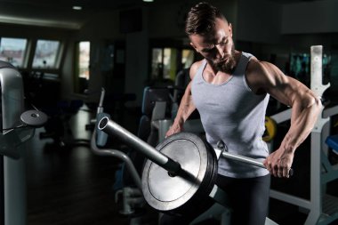 Yakışıklı sporcu ağır egzersiz sırt üstü ağırlıklar ile makine için yapmak