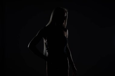 Studio - siyah arka plan üzerine izole poz Silueta sağlıklı genç kadın