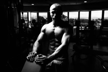 Yakışıklı ve çekici bir genç adam. Vücut kasları spor salonunda dinleniyor.