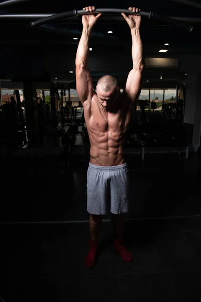 健康的青年男子站在健身房和肌肉伸缩 强运动后的肌肉运动健美健身模特 — 图库照片