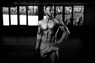 Tencere dibin kara seninki benden kara. Vücut geliştirici, ağırlık egzersizi yapıyor.