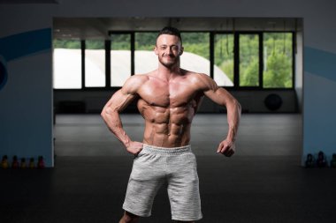 Spor Salonunda Güçlü Duran Genç Adam - Kas Atletik Vücut Geliştirici Spor Sonrası Spor Pozisyonu