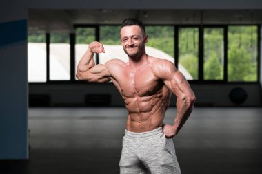 Spor Salonunda Güçlü Duran Genç Adam - Kas Atletik Vücut Geliştirici Spor Sonrası Spor Pozisyonu