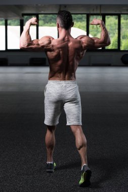 Spor Salonunda Güçlü Duran Genç Adam - Kas Atletik Vücut Geliştirici Spor Sonrası Spor Pozisyonu