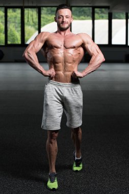 Spor Salonunda Güçlü Duran Genç Adam - Kas Atletik Vücut Geliştirici Spor Sonrası Spor Pozisyonu