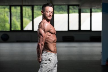 Spor Salonunda Güçlü Duran Genç Adam - Kas Atletik Vücut Geliştirici Spor Sonrası Spor Pozisyonu