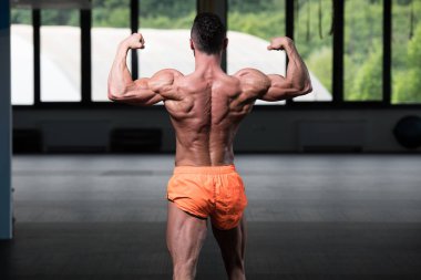 Spor Salonunda Güçlü Duran Genç Adam - Kas Atletik Vücut Geliştirici Spor Sonrası Spor Pozisyonu