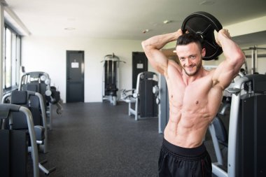 Elinde ağırlıkları olan genç bir adamın portresi.