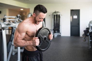 Elinde ağırlıkları olan genç bir adamın portresi.