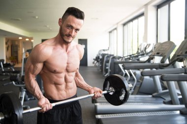 Kas Adam Spor Salonunda Halterli Kollar için Ağır Ağırlık Egzersizi Yapıyor