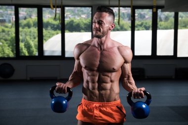 Tencere dibin kara seninki benden kara. Vücut geliştirici, ağırlık egzersizi yapıyor.