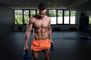 Tencere dibin kara seninki benden kara. Vücut geliştirici, ağırlık egzersizi yapıyor.