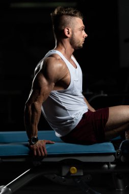 Yakışıklı ve çekici bir genç adam. Vücut kasları spor salonunda dinleniyor.