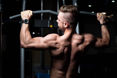 Yakışıklı Vücut Geliştirici Makineye Geri Dönmek İçin Ağır Ağırlık Egzersizi Yapıyor