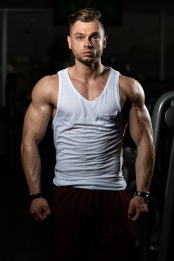 Spor salonu ve kasların esneme - güçlü ayakta sağlıklı genç adam kaslı atletik vücut Fitness Model çalışmaları sonra poz