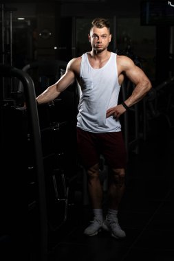 Yakışıklı ve çekici bir genç adam. Vücut kasları spor salonunda dinleniyor.