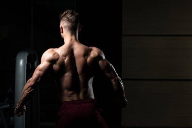 İyi eğitilmiş vücudunu gösteren genç bir adamın portresi - kaslı atletik vücut geliştirici spor sonrası vücut geliştirme modelliği pozu