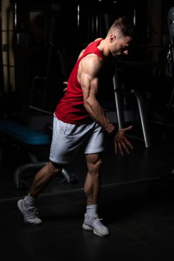 Yakışıklı Genç Adam Spor Salonunda Güçlü Duruyor ve Kaslarını Geriyor - Kas Atletik Vücut Geliştirici Spor Sonrası Spor Pozisyonu