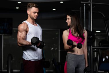 Pazı egzersiz donanımları ile spor salonunda için dumbell ile çalışma dışarı güçlü genç Çift