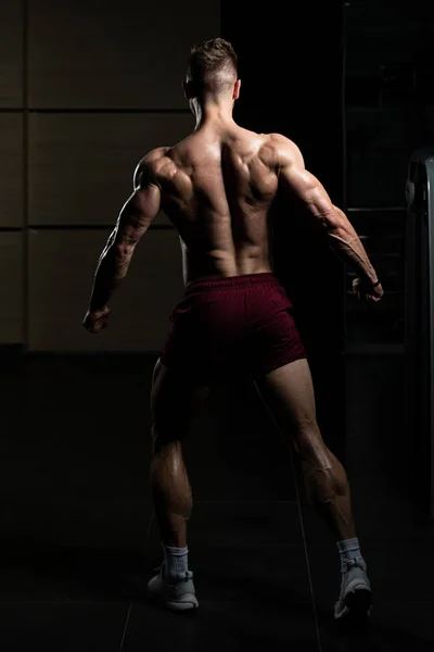 Schöner Junger Mann Der Stark Fitnessstudio Steht Und Die Muskeln — Stockfoto
