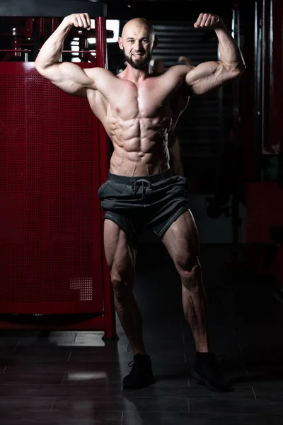 Hombres musculares está golpeando trasero doble bíceps Pose —  Fotos de Stock