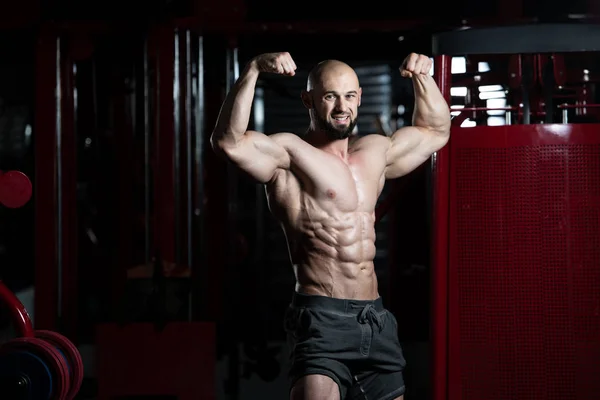 Bodybuilder presterende achterste dubbele biceps vormen — Stockfoto