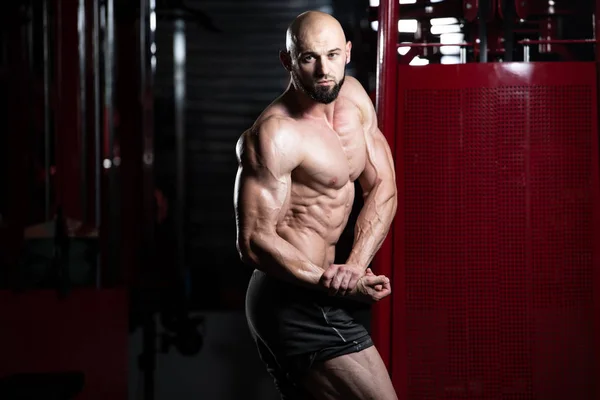 Seriöser Bodybuilder steht im Fitnessstudio — Stockfoto