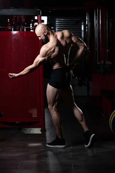 Musculoso hombre flexionando los músculos en el gimnasio —  Fotos de Stock
