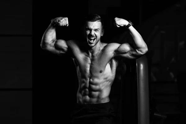 Bodybuilder flexar främre dubbel Biceps utgör i gymmet — Stockfoto