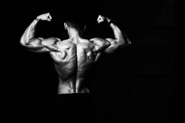Hombres musculares está golpeando trasero doble bíceps Pose — Foto de Stock