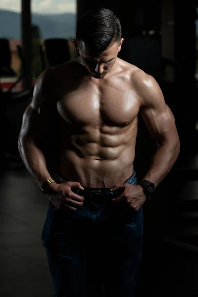 Jeune bodybuilder en jeans muscles flexibles — Photo